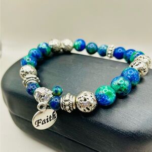 Faith charm beaded stretch bracelet with green, blue, and silver beads. Colorful